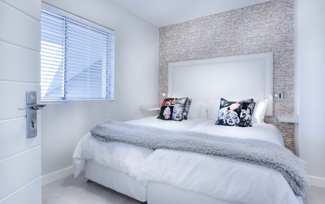 A white bedroom with a white bed and white pillows in Apartments in Westpark.
